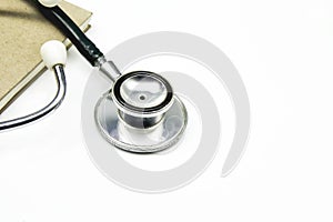 Medical stethoscope with notebook on white background