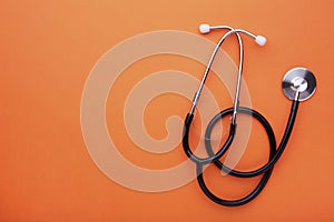 Medical stethoscope on a orange background. Health care concept