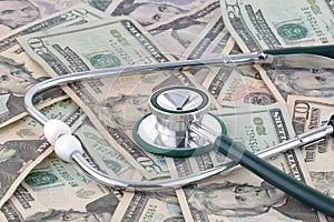 Medical stethoscope on a pile of money signifying the relationship of money and medicine