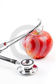 Medical stethoscope on red apple