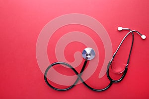 Medical stethoscope on red background. Health care concept