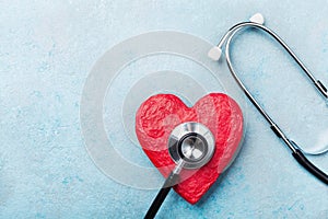 Medical stethoscope and red heart on blue background top view. Healthcare, pulse, heartbeat, medicare and cardiology concept.