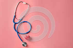 Medical stethoscope and red heart on color background. Cardiology concept