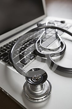 Medical Stethoscope Resting on Laptop Computer