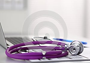 Medical stethoscope rests on top of a computer