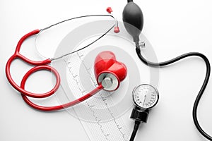 Medical stethoscope, sphygmomanometer, cardiogram and red heart on white background. Cardiology concept