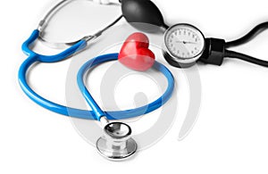 Medical stethoscope, sphygmomanometer and red heart on white background. Cardiology concept