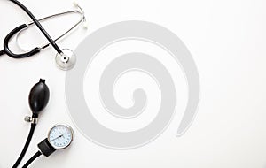 Medical stethoscope and sphygmomanometer on white background, top view