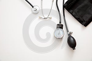 Medical stethoscope and sphygmomanometer on white background, top view
