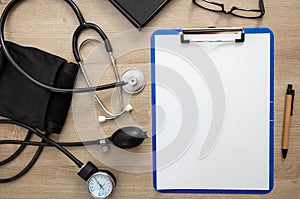 Medical stethoscope and sphygmomanometer on wooden background