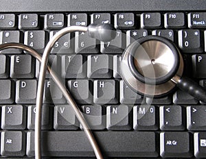 Medical stethoscope on top of laptop computer keyboard