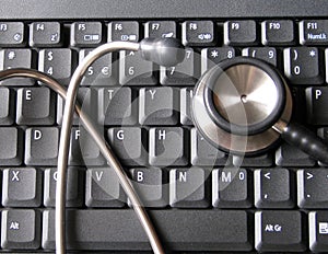 Medical stethoscope on top of laptop computer keyboard. Illustrative of healthcare and technology, informatics, bioinformatics