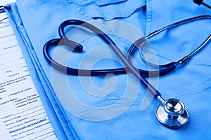 Medical stethoscope twisted in heart shape lying on patient medical history list and blue doctor uniform closeup