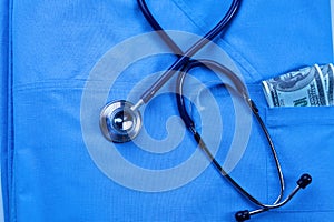 Medical stethoscope twisted in heart shape lying on patient medical history list and blue doctor uniform closeup