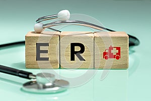 Medical stethoscope, wooden blocks with the inscription ER Emergency Room, ambulance icon, Health and life saving concept