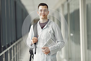 Medical student in with a backpack is standing in a modern clinic photo