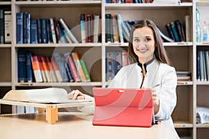 Medical student in library researching books