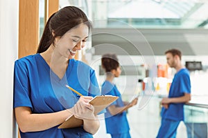 Medical student taking notes in hallway