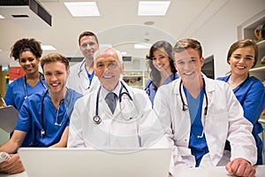 Medical students and professor using laptop