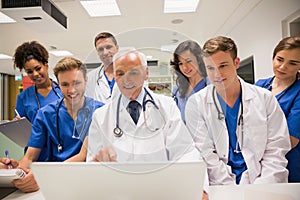 Medical students and professor using laptop