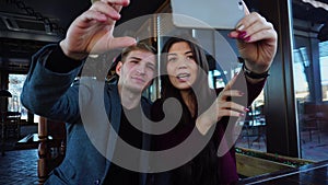 Medical students using smartphone to take selfie at cozy cafe