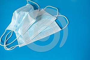 Medical surgical face masks covering the mouth and nose on a blue background.