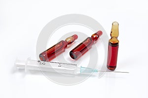 Medical syringe and ampoules on a white background.