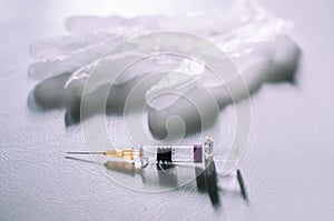 Medical syringe and gloves on a white background