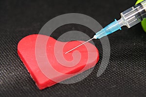 Medical Syringe and a Heart. Heart shaped object and a Cure.