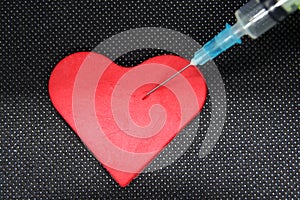 Medical Syringe and a Heart. Heart shaped object and a Cure.