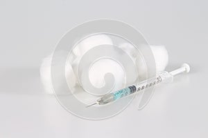 Medical syringe with needle and cotton ball on the white background