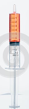 Medical Syringe with needle isolated on white, macro. Isolated syringe filled with red medication liquid. Fluid is like