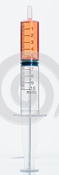 Medical Syringe with needle isolated on white, macro. Isolated syringe filled with red medication liquid. Fluid is like