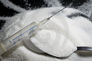 Medical syringe, pile of sugar grain in table spon, concept of d photo