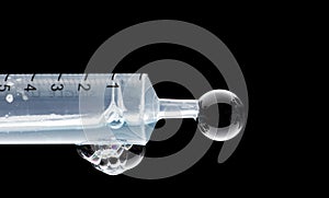 Medical syringe showing liquid bubbling and dripping has its expelled under pressure from syringe