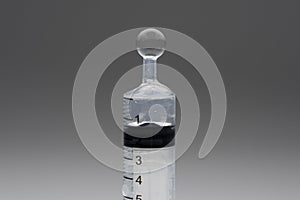 Medical syringe showing liquid bubbling and dripping has its expelled under pressure from syringe