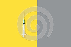 medical syringe in yellow and gray pantone color of the year background