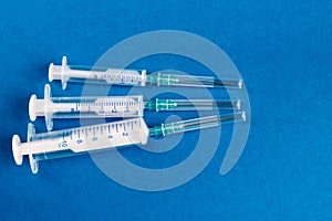 Medical syringes of different capacities lie on a blue surface photo