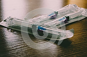 Medical syringes on a wooden table. Counterlight Macro. Soft focus. photo