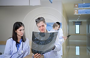 Medical teacher and interns analyzing the x-ray results of the patient\'s brain.