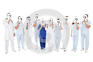 Medical Team Covering Faces With Question Mark Signs