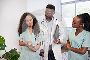 Medical team discuss patient case while standing looking serious, doctor nurses