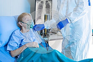 Medical team giving oxygen mask to the elderly covid-19 patient in quarantine room