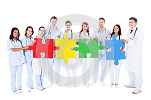 Medical team holding colorful puzzle pieces