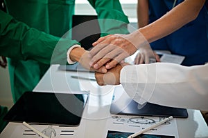 The medical team joins hands after the meeting and discusses the treatment of severely ill patients and can come to a conclusion