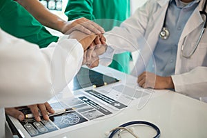 The medical team joins hands after the meeting and discusses the treatment of severely ill patients and can come to a conclusion