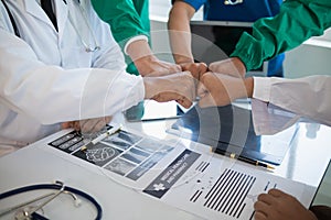 The medical team joins hands after the meeting and discusses the treatment of severely ill patients and can come to a conclusion