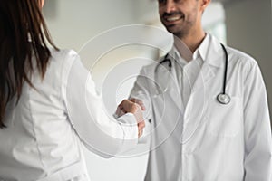 Medical team male doctor and female nurse shake hands