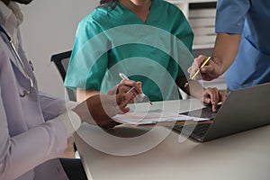 Medical Team Meeting Around Table In Modern Hospital