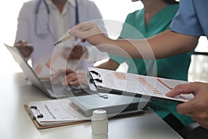 Medical Team Meeting Around Table In Modern Hospital